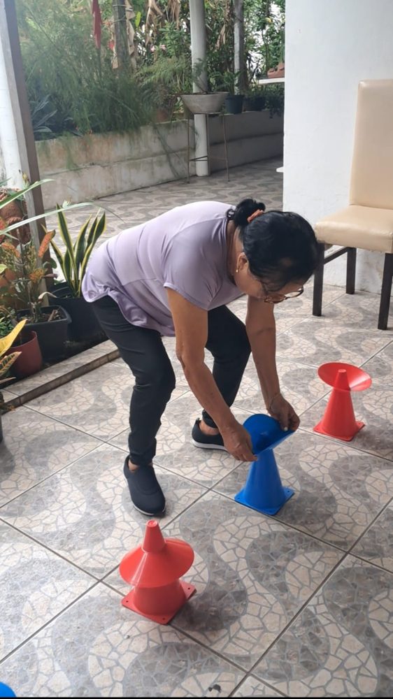 Aluna pegando cones no chão durante o treino