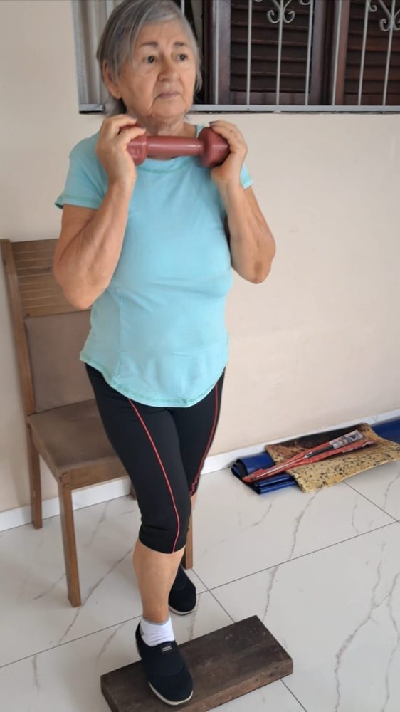 Aluna com halter no step em casa